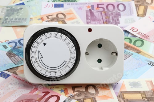 Preview: Closeup of a light timer on a spread of Euro banknotes - computing electricity costs