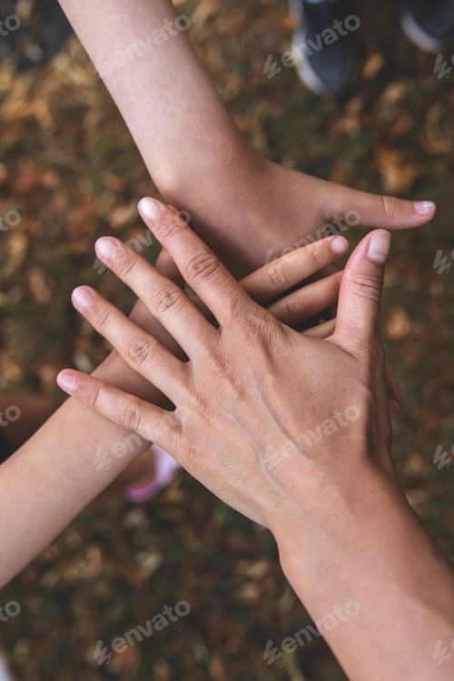 Preview: The hand of an adult and two children together, a symbol of friendship.
