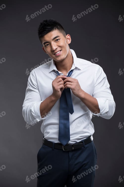 Preview: Young muscular man tying tie