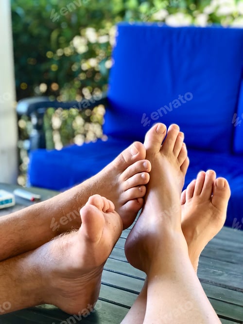 Preview: 2 people playing footsie with each other while relaxing on the porch