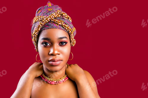 Preview: glamour dark skin woman wrapped on turban in studio in red background