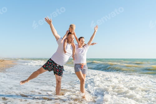 Preview: happy family with little son walk along seashore on a sunny day, the concept of family and vacation