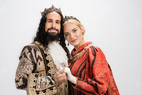 Preview: happy historical interracial couple in crowns and medieval clothing isolated on white