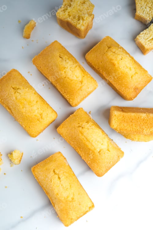 Preview: Close-up of corn muffins on plate with bowl of corn meal and additional muffins in the background.
