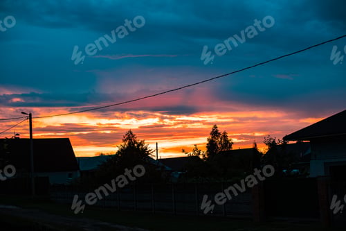 Preview: Landscape sunset in the village. Cloudy, sunset. Private homes, trees