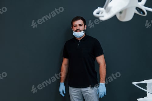 Preview: Portrait of dentist in gloves that standing indoors in the clinic