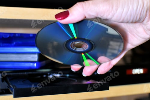 Preview: Woman putting a Blu-ray DVD disc into a player for movie night.