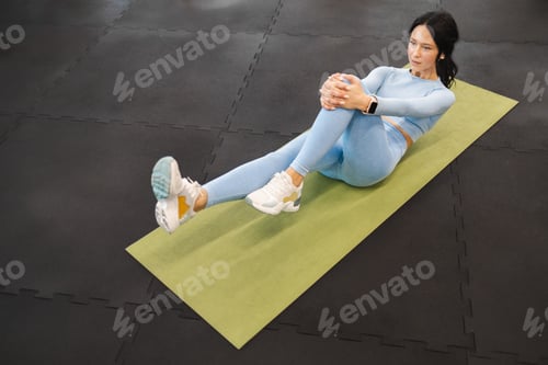 Preview: Female athlete doing abs exercising sit-ups on the yoga mat