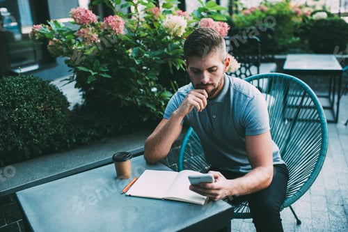 Preview: Young bearded man studying in cafe
