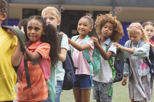 Preview: Front view of school kids standing in a queue at schoolyard with backpack