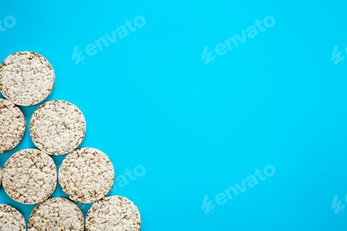 Preview: Puffed rice cakes on blue background, flat lay, copy space.