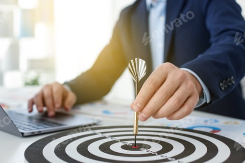 Preview: Man with dart aiming at dartboard while working indoors, closeup