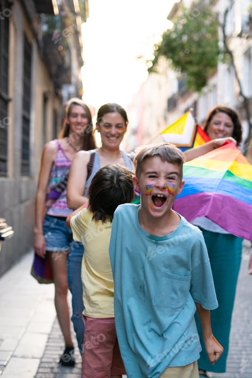 Preview: Families celebrating gay pride parade with rainbow flag and painted faces