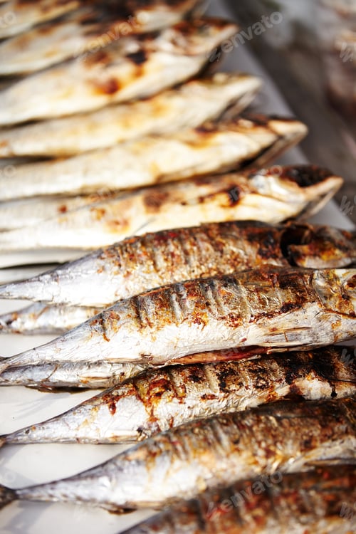 Preview: Packed like sardines. Closeup of cooked sardines in row ready for eating at a Thai market stall.