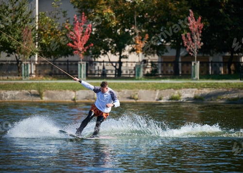 Preview: Young surfer having fun wakeboarding in the cable park.