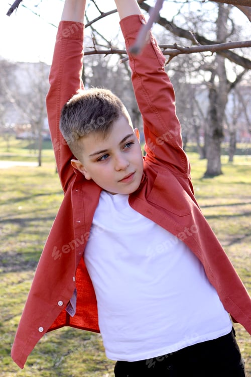 Preview: A blond boy with a fashionable haircut in a coral shirt and a white T-shirt went for a walk