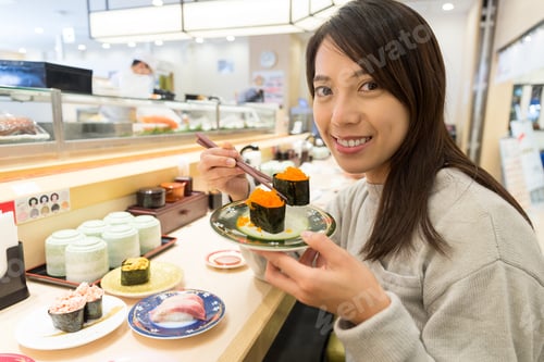 Preview: Woman enjoy sushi in restaurant
