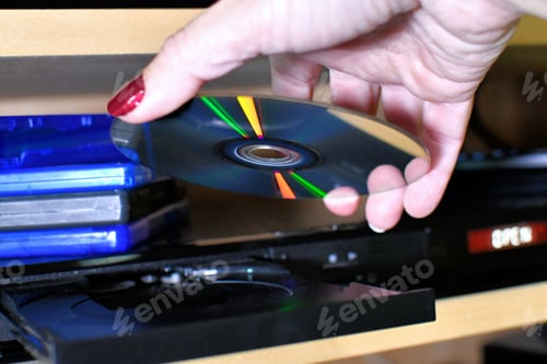 Preview: Woman putting a Blu-ray DVD disc into a player for movie night.