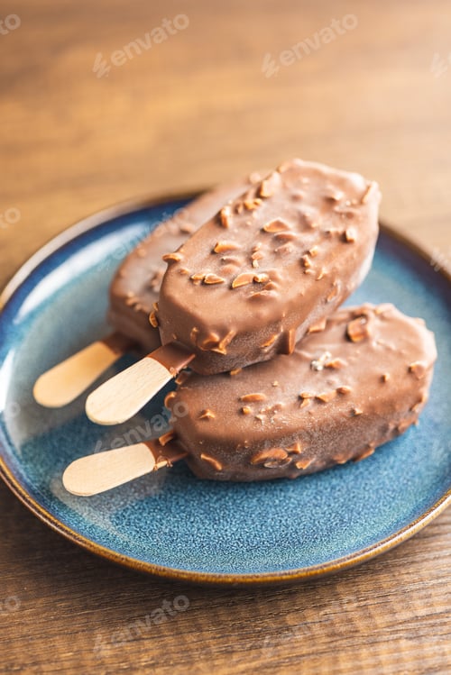 Preview: Popsicle, ice cream covered with chocolate on wooden table.