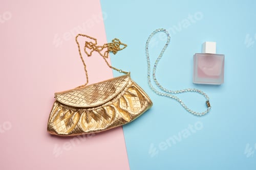 Preview: Golden clutch bag with various cosmetics and jewelry on a blue background