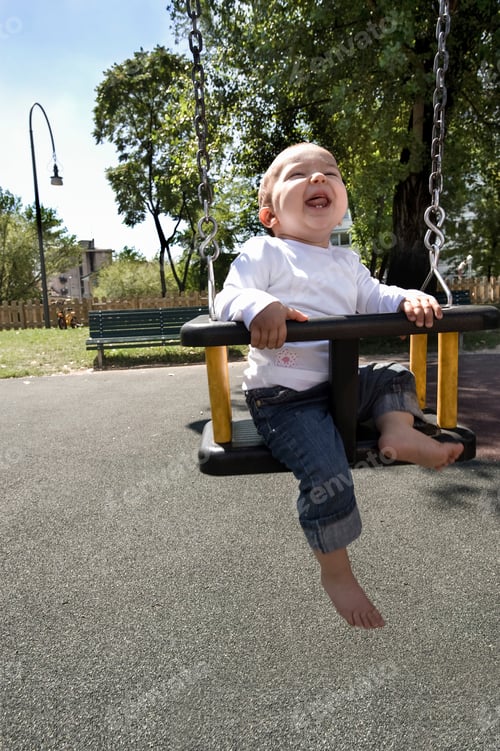 Preview: Joyful toddler enjoying a sunny day at the park on a swing