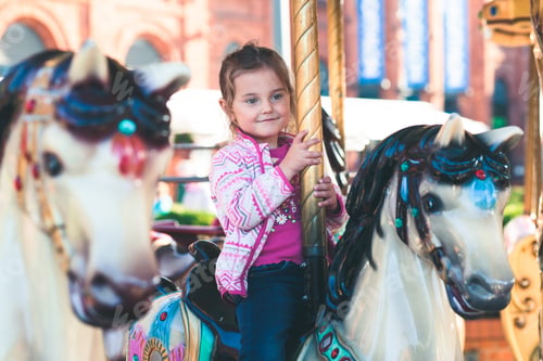 Preview: Girl riding horse on roundabout carousel at funfair. Having fun. Kids childhood. Playing outdoors