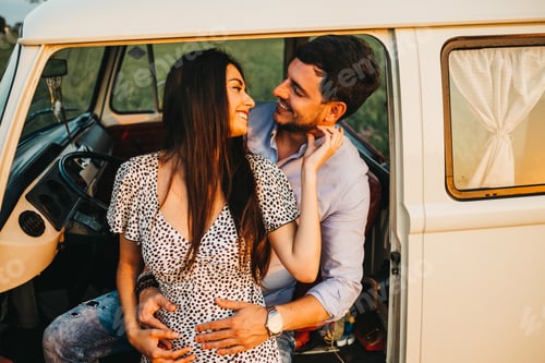Preview: Couple kissing and embracing at van
