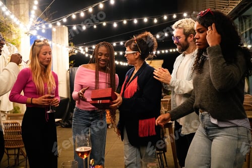 Visualização: Amigos dando presentes na festa de aniversário no terraço