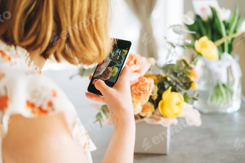 Preview: Young woman shoots bouquet of flowers in box on mobile phone