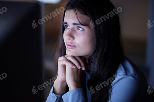Preview: Thinking, working and woman in office at night reading information on computer while doing research