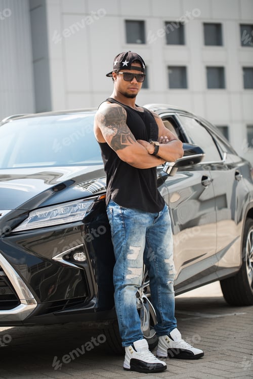Preview: An African-American man poses near his car