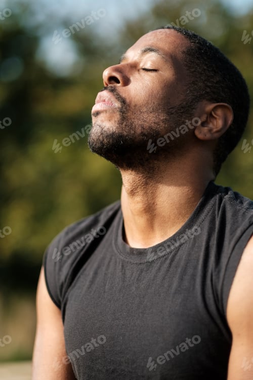 Preview: Young athlete breathing deeply in a park: practicing mindfulness