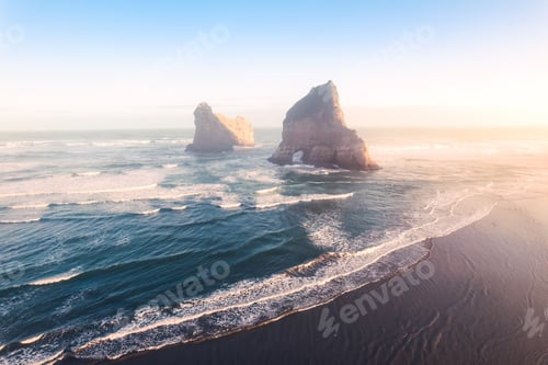 Preview: Sunrise shining over Wharariki beach and archway islands on Tasman sea at Cape Farewell, New Zealand