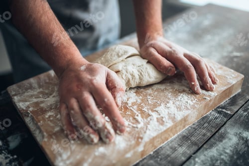 Preview: Baker hands kneading the dough with flour