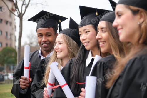 Preview: Happy multi ethnic graduates holding diplomas are smiling in front of university