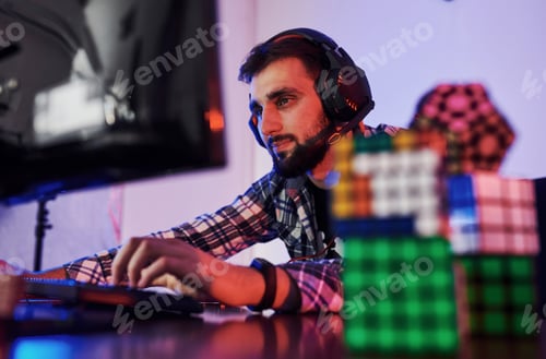 Preview: Portrait of young bearded pro gamer playing in online video game