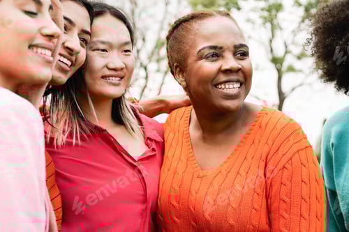 Preview: Diverse group of women having fun together. Happy multicultural people hugging each other outdoor