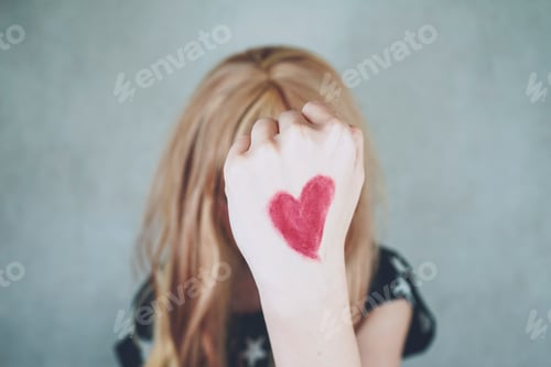 Preview: Strong woman with a red heart drawing in her hand