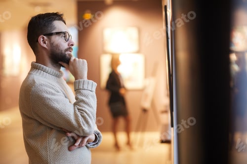 Preview: Bearded Man Looking at Paintings in Art Gallery