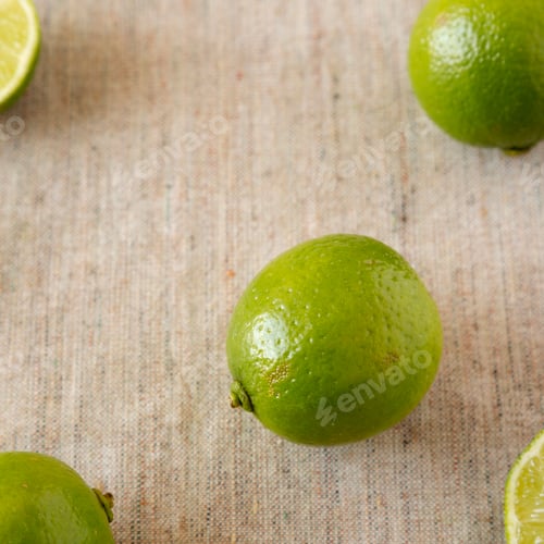 Preview: Green citrus limes on cloth, low angle view. Close-up.