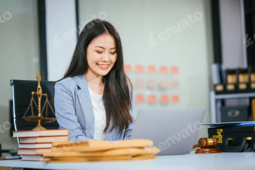 Preview: An Asian female lawyer conducts online consultations using laptop in her office.She reviews legal