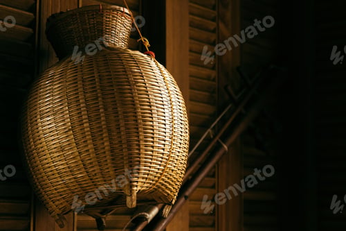 Preview: Closeup of straw wicker basket hanging on wooden wall.