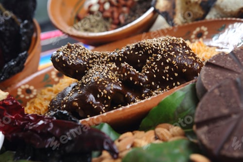 Preview: Chicken covered in Mexican mole sauce, sesame seeds next to cooked rice on the plate