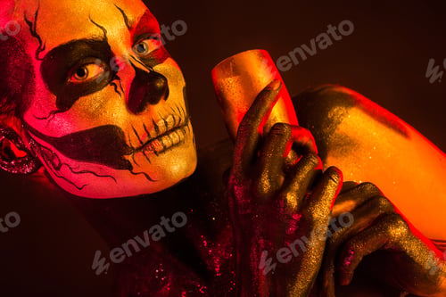 Preview: Pretty girl with skeleton makeup holds glass