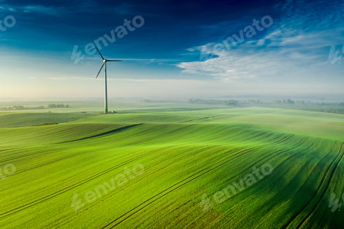 Preview: Wonderful foggy wind turbine on green field at sunrise, Poland