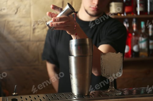 Preview: Bartender preparing fresh alcoholic cocktail at bar counter, closeup