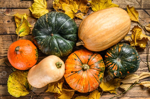 Preview: Autumn Pumpkins with maple leaves on wooden table. Wooden background. Top view