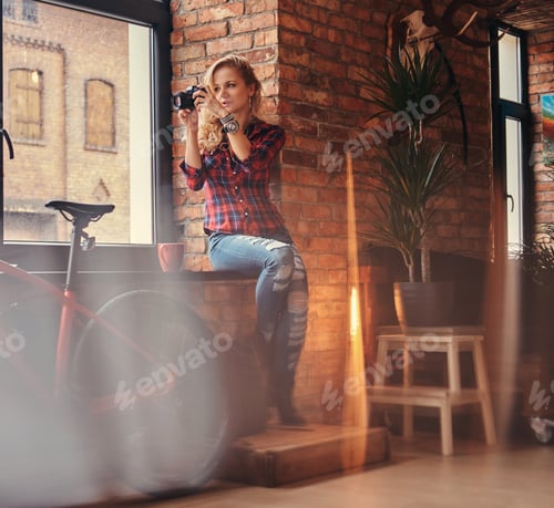 Preview: Sensual blonde hipster girl in a studio with loft interior.