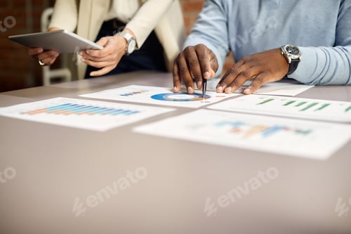 Preview: Close up of business people analyzing charts during a meeting in the office.