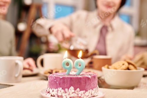 Preview: Two burning nine-shaped candles on glazed delicious homemade cake on table